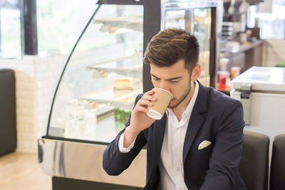 Businessman drinking coffee while sitting in cafe
