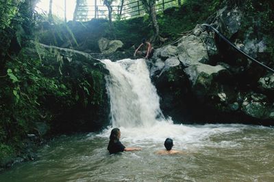 People surfing on rocks in forest