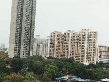 Buildings in city against clear sky