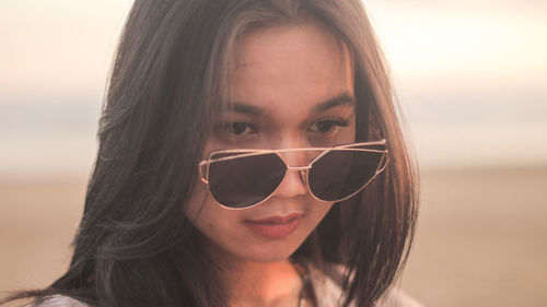Close-up portrait of young woman wearing sunglasses