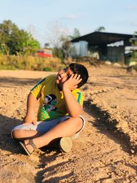 Young woman sitting on sand