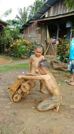 High angle view of shirtless man sitting outside house
