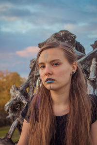 Portrait of young woman against sky