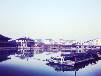 Reflection of built structure in water against clear sky