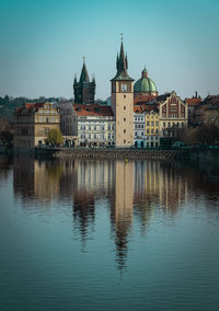 Buildings by river with reflection