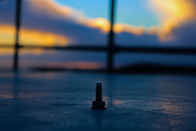 Close-up of metal table against sky during sunset