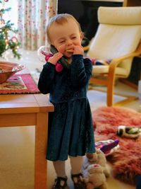 Girl eating food while talking on phone at home