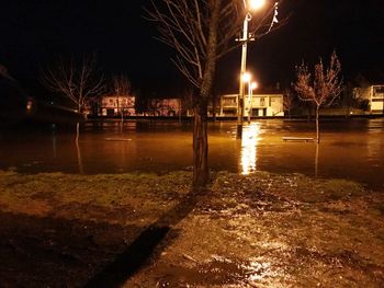 Reflection of illuminated buildings in puddle at night