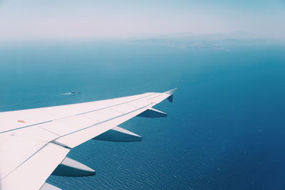 Airplane flying over sea against sky