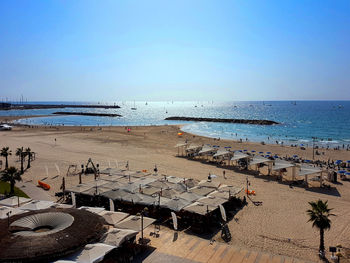 High angle view of people on beach against clear sky