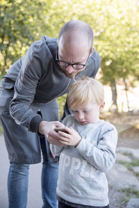 Father and son looking at cell phone