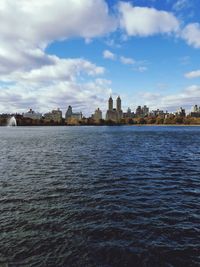 River by cityscape against sky