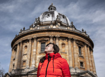 Low angle view of woman standing against cathedral