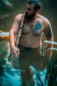 Full length of shirtless man swimming in sea
