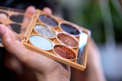 Close-up of hand holding make-up palette 