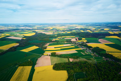Aerial view of landscape with blooming rapeseed on agricultural fields