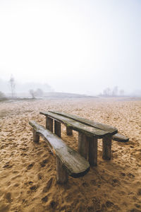 Empty chairs on field against sky