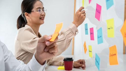 Portrait of woman holding christmas presents at office