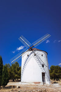 Traditional windmill on field against sky