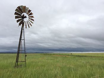 Traditional windmill on field against sky