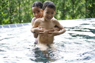 Portrait of happy boy playing in water