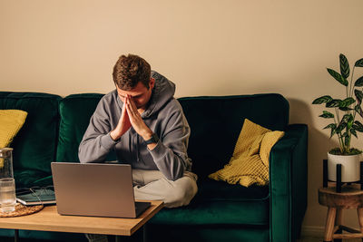 Young woman using laptop while sitting at home