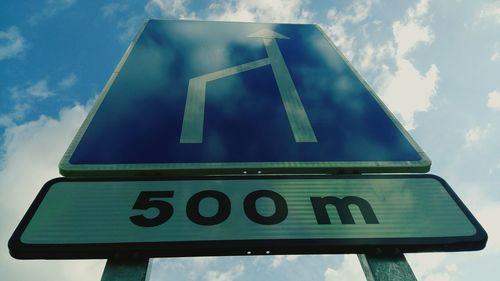 Low angle view of road sign against sky