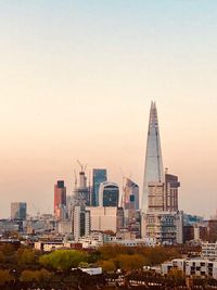 Modern buildings against clear sky during sunset