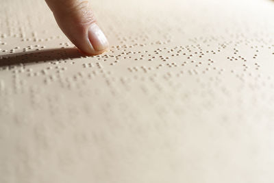 A finger following the reading of a page written in the braille alphabet, the tactile reading system