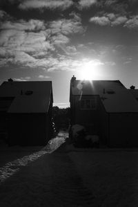 Road by buildings against sky in city