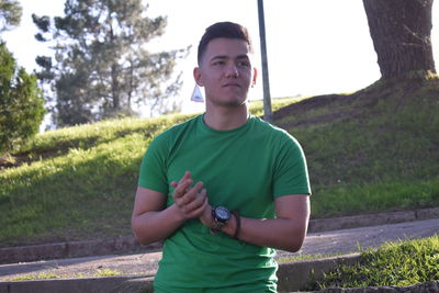 Full length portrait of young man standing against plants