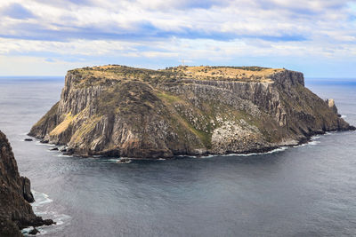 Scenic view of rocks in sea against sky