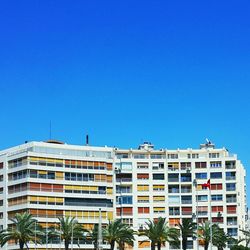 Low angle view of buildings against clear blue sky