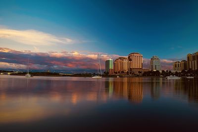 Buildings by river against sky at night