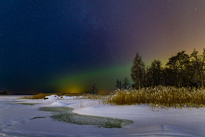 Snow covered field against sky at night