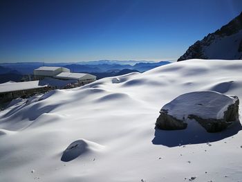 Scenic view of snowcapped mountains against clear blue sky