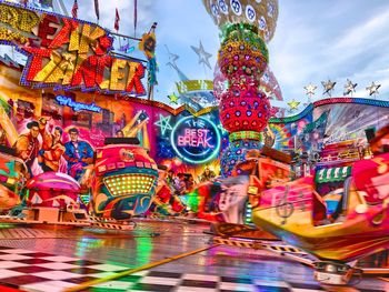 Multi colored carousel in amusement park against sky