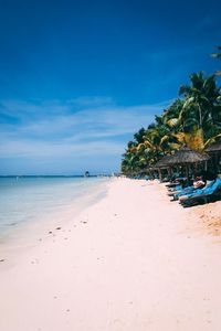 Scenic view of beach against blue sky