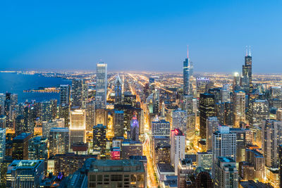 Aerial view of city lit up at dusk