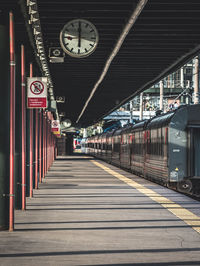 Rear view of man walking on railroad station