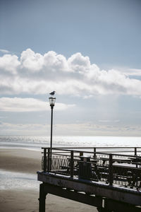 Railing by sea against sky