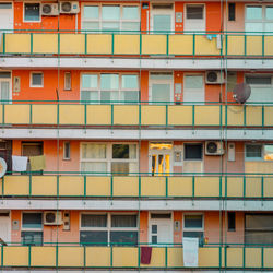 Facade of a building with orange and green balcony