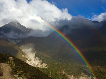 Scenic view of rainbow over mountains against sky