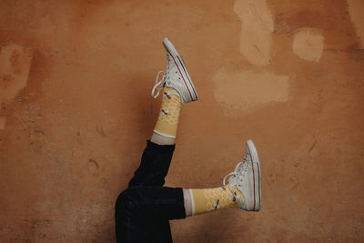 Low section of woman standing by wall