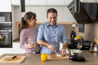 Friends standing in kitchen at home