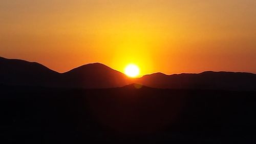 Scenic view of silhouette mountains against sky during sunset