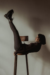 Side view of young woman sitting on chair