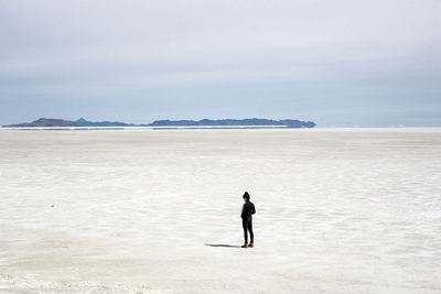 Man standing on shore against sky