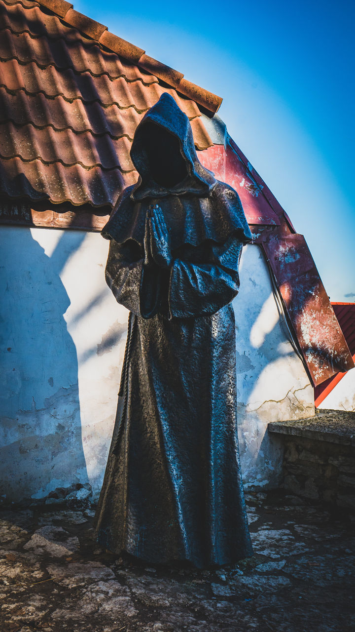 LOW ANGLE VIEW OF STATUE AGAINST WALL