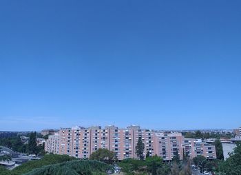 High angle view of buildings against clear blue sky
